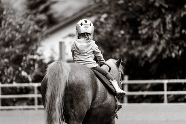Ein Kind reitet auf einem Pferd